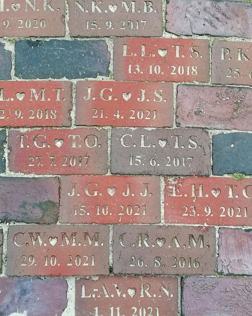 Ziegelsteinpflaster vor dem Standesamt von Langeoog mit eingravierten Initialen und Hochzeitsdatum der Paare